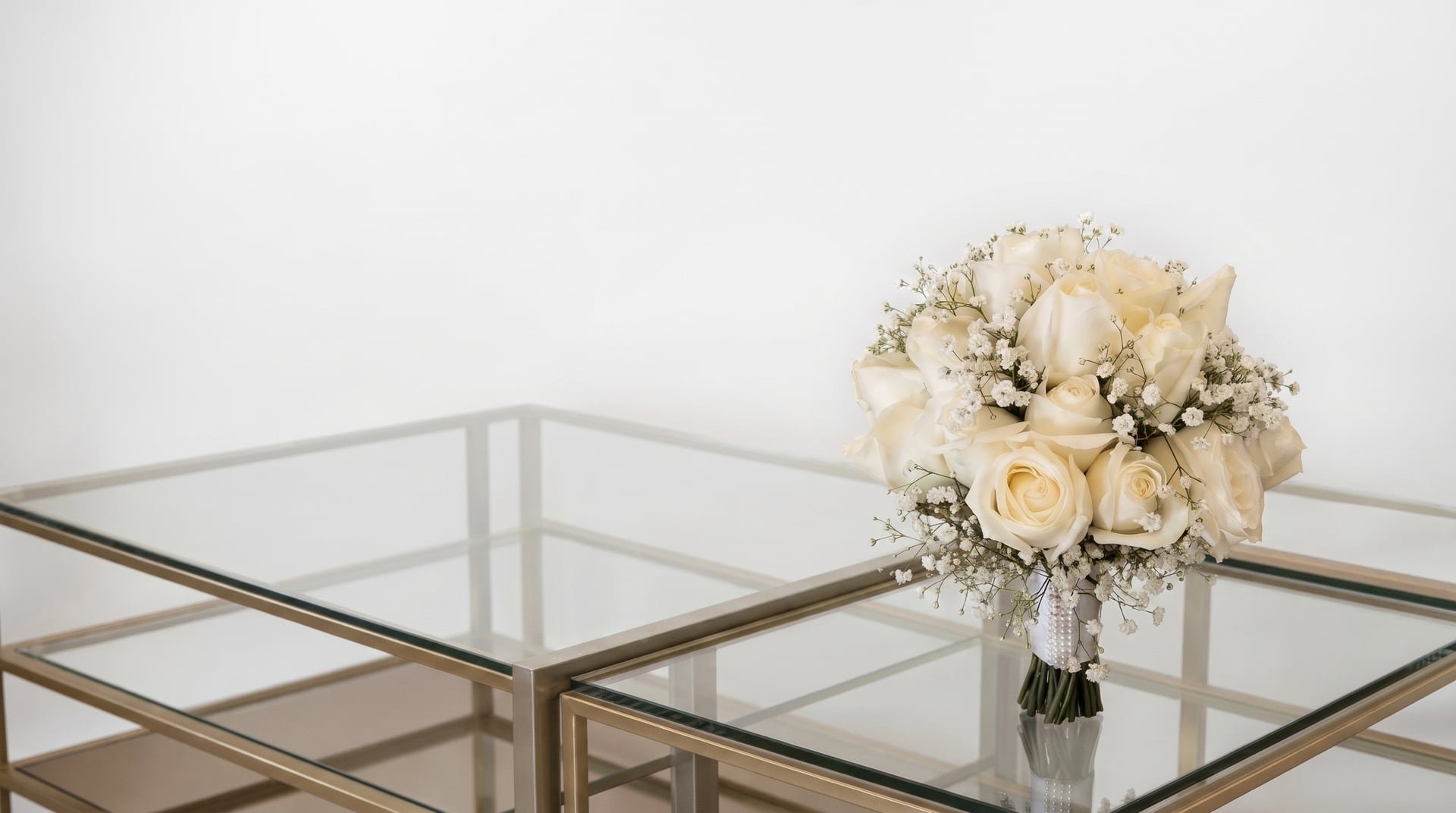 Buquê de rosas brancas sobre mesa de vidro